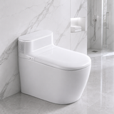 A modern white smart toilet with a closed lid, positioned in a clean bathroom setting with white marble walls and floor, and a glass shower enclosure in the background.