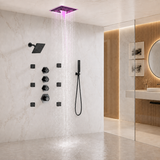 Modern wall-mounted rain shower system with a square overhead shower head emitting pink-purple water light, a handheld wand attachment, multiple black control valves, and a glass-enclosed bathroom interior.